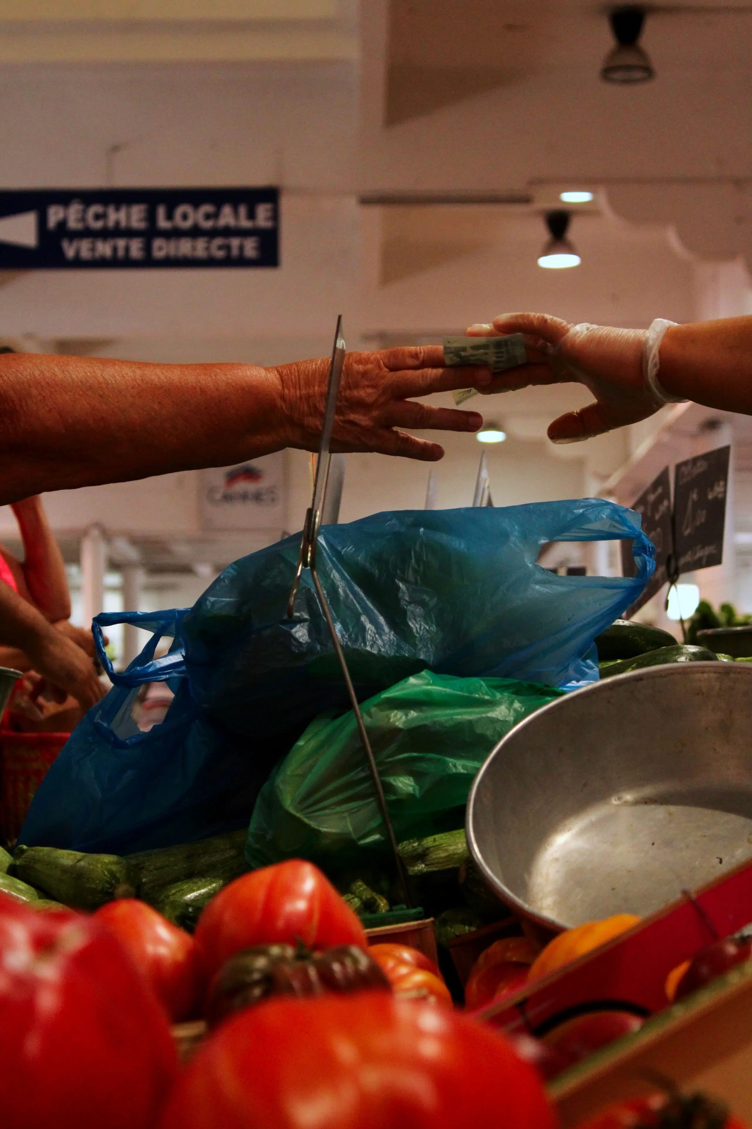 Échange d'argent sur un marché local, illustrant l'impact économique positif des vacances éthiques et du tourisme responsable.